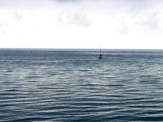 A yacht going on a small sea trip, in cloudy weather and a slight sea disturbance.