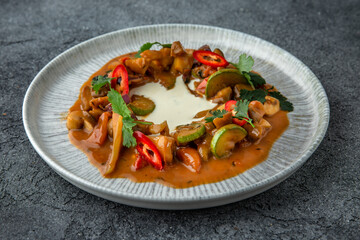 Vegetable stew with pieces of meat in a creamy sauce. Ready menu for the restaurant. Neutral gray blue textured background