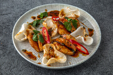 Grilled squid with rice chips sauce. Ready menu for the restaurant. Neutral gray blue textured background