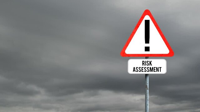 Attention signboard post with risk assessment text against dark clouds in the sky