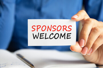 sponsors welcome written on a paper card in woman hand