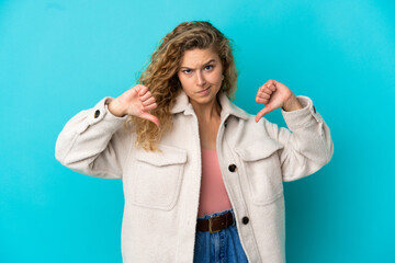 Young blonde woman isolated on blue background proud and self-satisfied