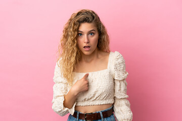 Young blonde woman isolated on pink background pointing to oneself