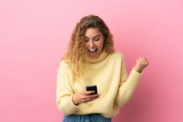 Fototapeta premium Young blonde woman isolated on pink background surprised and sending a message