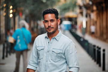 Naklejka premium Portrait of a dark-haired Latin boy posing for a photo session on a street in the city of Barcelona..