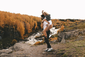Happy cheerful couple in love newlyweds two people in casual clothes travel together hike and walk in the local autumn forest in nature on vacation enjoy the landscape of outdoor activities
