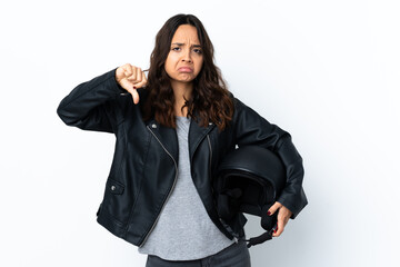 Young woman holding a motorcycle helmet over isolated white background showing thumb down