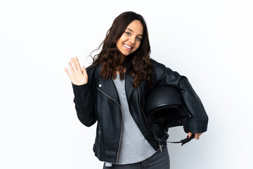 Fototapeta premium Young woman holding a motorcycle helmet over isolated white background saluting with hand with happy expression