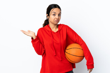 Young woman playing basketball over isolated white background making doubts gesture