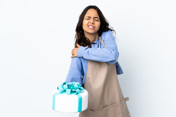 Pastry chef holding a big cake over isolated white background suffering from pain in shoulder for having made an effort