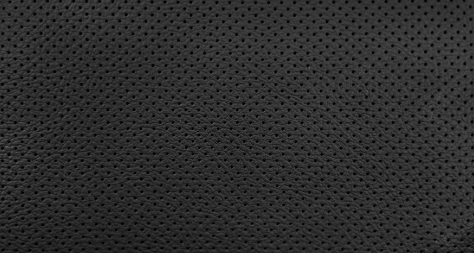 Closeup black leather of interior material for sport car. Modern, luxury and quality element for design decorative. Rough texture background. Pattern wallpaper.
