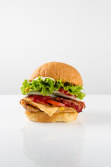cheese burger, with meat, chicken, bacon, tomatoes, onion, lettuce, potatoes, french fries, ketchup. white background
