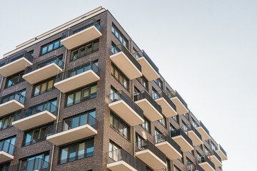 modern brick apartment house with white balcony