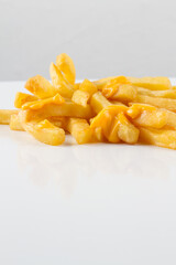 french fries with melting cheese. white background with reflection
