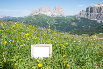 Empty wooden picture frame mockup in sunlight with mountains in the background. Summer vacation in the mountains. Template for articles and equipment for the mountain. Advertising for natural products
