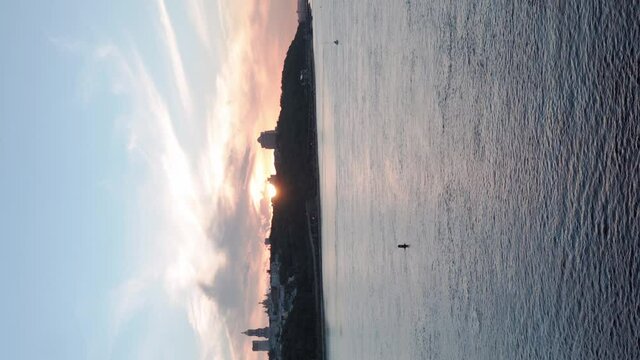 Vertical video Top Aerial view Colored evening summer sky. sailing motor boat with angler on Dnipro river at sunrise sunset. landscape of bridge over lake in Kiev Ukraine city. water transport, travel
