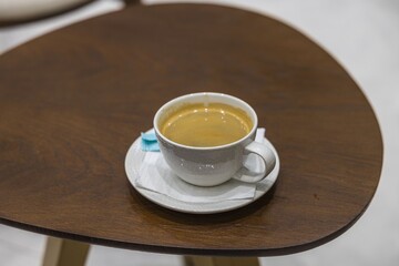 Close up view of cup of coffee on wooden brown table. Greece. 