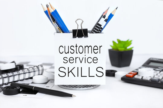 Customer Service Skills. text attached to pencil case with crayons on white background