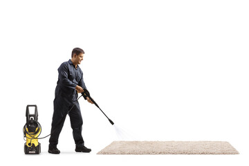 Full length shot of a male worker cleaning a carpet with a pressure washer machine
