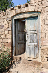 Fototapeta na wymiar old wooden door in abandoned ruined house in ancient village Gamsutl, Dagestan