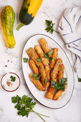 Zucchini nuggets served with parsley and sour cream sauce with mustard. Delicious vegetarian dish. Top view. 