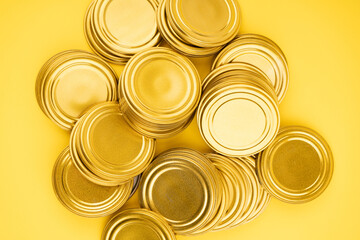 Lids for jars of gold color top view on a yellow background.