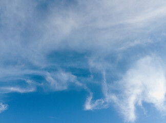 summer blue sky illuminated by the sun and illuminated by white fluffy clouds. Natural background for design, copy space.