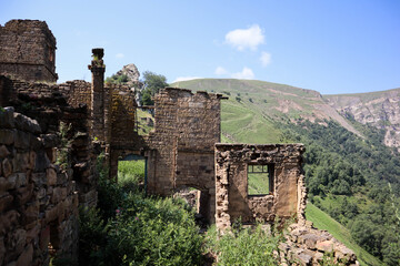 beautiful morning view to the ruined houses of abandoned ancient village Gamsutl in Dagestan with scenery mountain landscape on the background