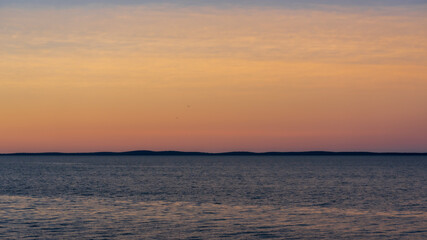 Fototapeta na wymiar Glowing sky at sunset, over the bay