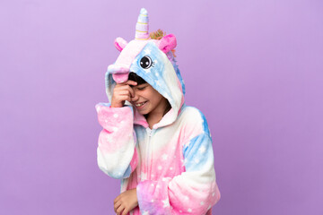 Obraz na płótnie Canvas Little kid wearing a unicorn pajama isolated on purple background laughing