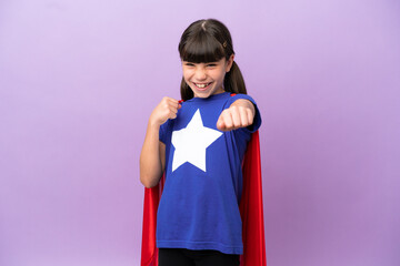 Little kid isolated on purple background in superhero costume and fighting
