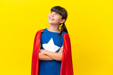 Little super hero kid isolated on purple background looking up while smiling