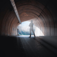 man alone standing in a tunnel