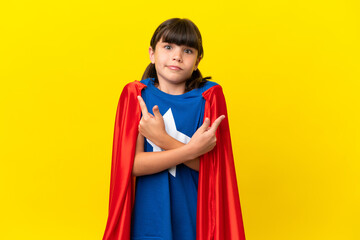 Little super hero kid isolated on purple background pointing to the laterals having doubts