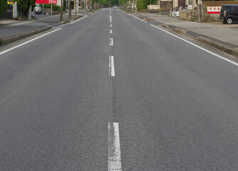 センターラインがかすれて古い二車線の直線の舗装道路