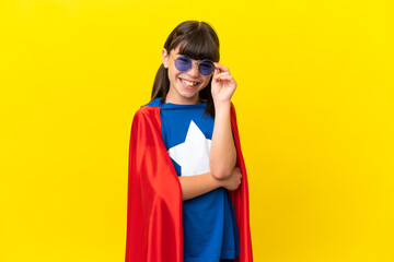 Little super hero kid isolated on purple background with glasses and happy