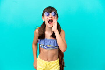 Little caucasian kid going to the beach isolated on blue background shouting with mouth wide open