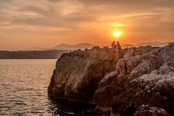 Deux amoureux regardant un coucher de soleil sur la baie des anges à Nice sur la Côte d'Azur 