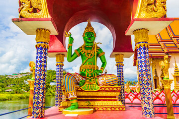 Green god statues and architecture Wat Plai Laem temple Thailand.