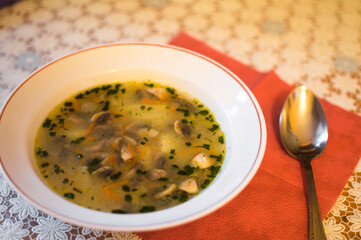 Fresh mushroom soup in a plate and a spoon on the table
