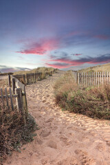 Path to the beach through the dunes at the sunset