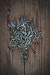 A bundle of sage lies on a wooden table
