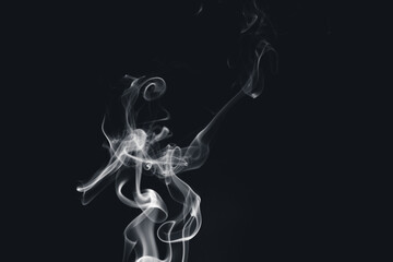 A white smoke creating abstract shapes on a black background