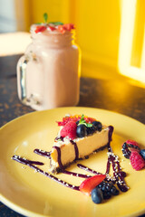Smoothie and cheesecake with yellow background. Concept of healthy