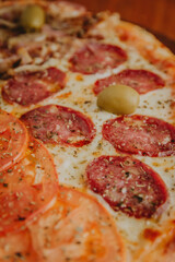 foreground pizza with salami and olives