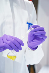 Researcher holds a flask with chemicals and reagents in his hands