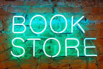 Neon letters, bright signboard bookstore on a brick wall close-up.