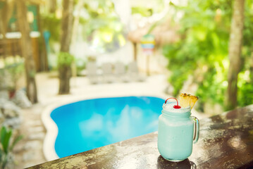 Colorful tropical cocktails on wooden bar. Mixology in pool holiday