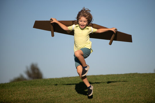 Child to be pilot. Kid with paper wings flying. Summer vacation and travel concept. Funny child boy with toy cardboard airplane wings fly on sky. Startup freedom and kids carefree concept.