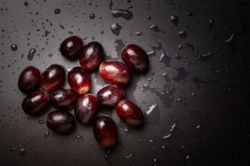 Close up of red grapes on black background with copy space.